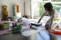 Дівчина в гаражному живописі з малярським валиком — стокове фото