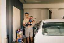 Père tenant son fils dans le garage — Photo de stock
