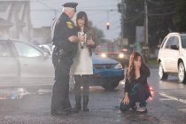 Police officer and young women at scene of accident — Stock Photo
