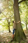 Жінка обіймає дерево в парку — стокове фото