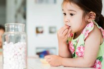 Close up of young girl tasting marshmallows — Stock Photo