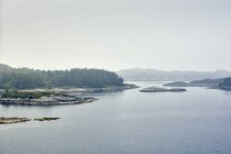 Vue sur l'eau des îles avec sapins et chaîne de montagnes — Photo de stock