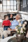 Grandfather and grandson using digital tablet at home — Stock Photo