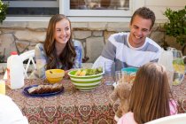 Sisters and brother having breakfast outdoors — Stock Photo