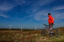 Mountain biker at a wind farm. — Stock Photo