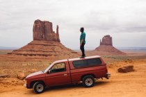 Young man looking out from top of four wheel drive, Monument Valley, Arizona, USA — Stock Photo