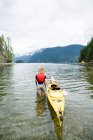 Kayak de mujer en fiordo - foto de stock