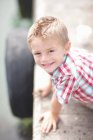 Porträt eines kleinen Jungen, der sich an eine Pfeilerwand lehnt — Stockfoto