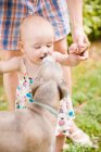 Dog licking baby girl?s face — Stock Photo