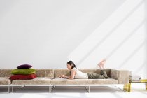 Japanerin entspannt sich auf Sofa — Stockfoto