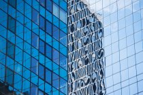 Rascacielos urbano reflejado en ventanas - foto de stock