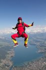 Femme parachutisme sur le paysage rural — Photo de stock