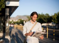 Homem lendo jornal na estação ferroviária — Fotografia de Stock