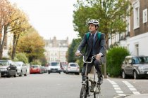 Середній дорослий бізнесмен їде на велосипеді на вулиці — стокове фото