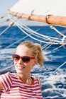 Donna seduta su una barca a vela — Foto stock