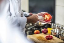 Chef de-seeding red pepper with knife — Stock Photo