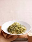 Teller mit Pesto-Pasta an Bord mit Stoffserviette — Stockfoto