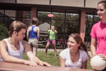 Équipe d'élèves du secondaire de volleyball parlant à l'extérieur du lycée — Photo de stock