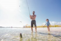 Tochter beobachtet Vater beim Fischfang im Meer, Fort Walton Beach, Florida, USA — Stockfoto