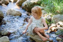Chica jugando en el río - foto de stock