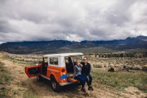 Casal com veículo em matagal por montanhas, Kennedy Meadows, Califórnia, EUA — Fotografia de Stock