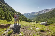 Visão traseira do jovem casal em pé em pedra com vista para as montanhas, Val Senales, Tirol do Sul, Itália — Fotografia de Stock