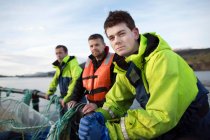 Lavoratori nell'allevamento di salmoni nel lago rurale — Foto stock