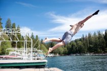 Mann springt von Steg in den See — Stockfoto