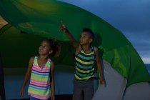 Brother and sister in tent, boy pointing — Stock Photo