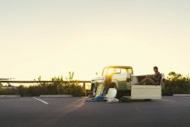 Junge Surferin schaut in einem Pickup-Truck am Strand von Newport, Kalifornien, USA auf ihr Smartphone — Stockfoto