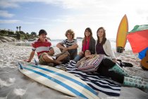 Freunde am Strand mit Surfbrett — Stockfoto