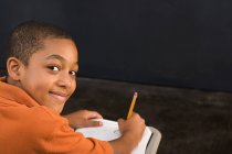 Портрет хлопчика, що пише з олівцем — стокове фото
