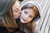 Мать целует дочь в щеку, высокий угол портрет — стоковое фото