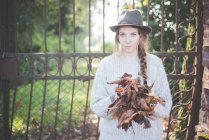 Молода жінка збирає осіннє листя — стокове фото