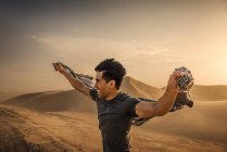 Uomo che tiene la sciarpa nel vento, dune di sabbia Glamis, California, Stati Uniti d'America — Foto stock