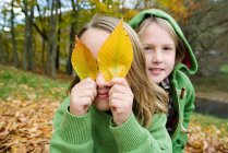 Mädchen spielen mit Blättern im Freien — Stockfoto