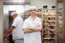 Усміхнений шеф-кухар стоїть на кухні — стокове фото
