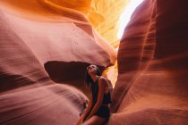 Жінка дивиться на сонячне світло в печері, Каньйон Антилопи, сторінка, Арізона, США — стокове фото