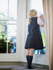 Little girl looking out of the window — Stock Photo
