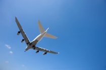 Vue à faible angle de l'Airbus A380 volant dans un ciel bleu sans nuages pendant la journée — Photo de stock
