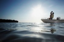 Coppia anziana che si abbraccia in barca a motore — Foto stock