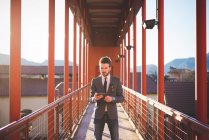 Молодий чоловік використовує цифровий планшет на пішохідному мосту — стокове фото