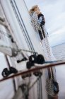 Жінка стоїть на човні, носить мотузку на плечі — стокове фото