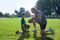 Хлопчик і дідусь з американським футболом — стокове фото