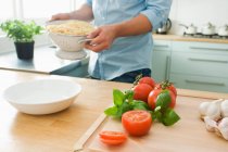 Abgeschnittenes Bild eines Mannes, der Spaghetti mit Tomaten kocht — Stockfoto