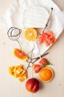 Квартира с апельсинами, сыром и цветами — стоковое фото