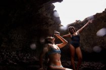 Amigos en cueva vistiendo trajes de baño y posando, Oahu, Hawaii, EE.UU. - foto de stock