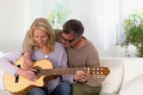 Hombre y mujer rasguñando guitarra - foto de stock