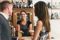 Официантка, обслуживающая молодую пару в коктейль-баре — стоковое фото