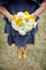 Подружка невесты с желтым букетом и туфлями — стоковое фото